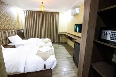 a hotel room with two beds and a television at Beirut Hotel 2 in Amman