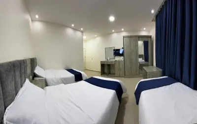 a hotel room with three beds and a television at Petra Heaven Boutique in Wadi Musa