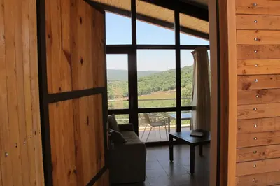 a living room with a large window and a couch at Ajloun Forest Reserve in Jerash