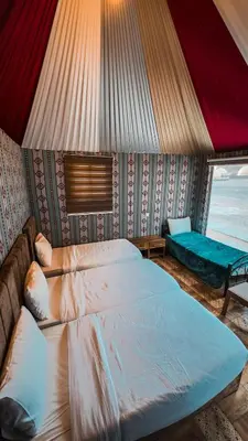 a bedroom with a large bed and a window at Nada luxury camp in Wadi Rum