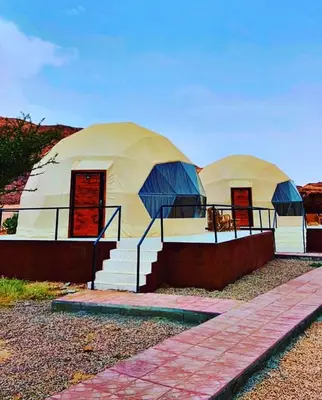 two domed tents with stairs in front of them at Khaled Rum Camp in Disah