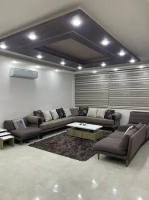 a living room with a couch and a table at شقة مفروشة in Rujm Maghghijhah