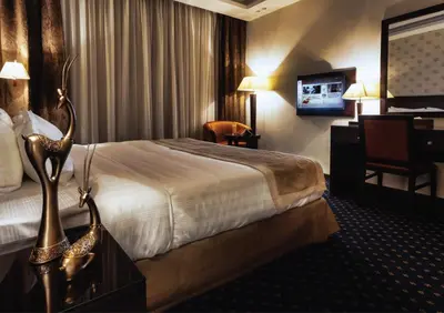 a hotel room with a large bed and a desk at فندق سفن روزز in Amman