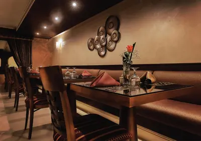 a restaurant with a bar with a table and chairs at فندق سفن روزز in Amman