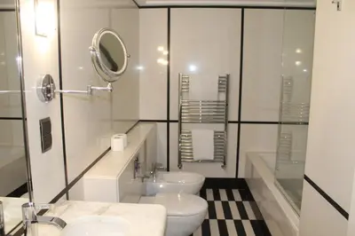 a white bathroom with two toilets and a mirror at Boulevard, Abdali Luxury 1 BR Apartment in Amman
