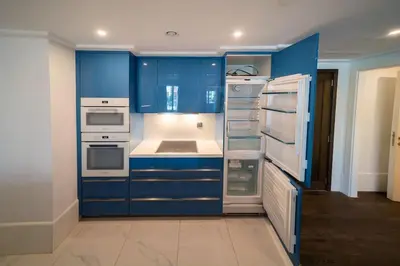 a kitchen with blue cabinets and white appliances at Boulevard, Abdali Luxury 1 BR Apartment in Amman