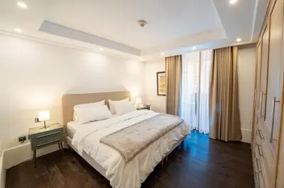 a bedroom with a large bed and a window at Boulevard, Abdali Luxury 1 BR Apartment in Amman