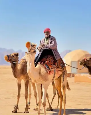 a man riding on the back of a camel at Rum Star Desert Camp in Wadi Rum