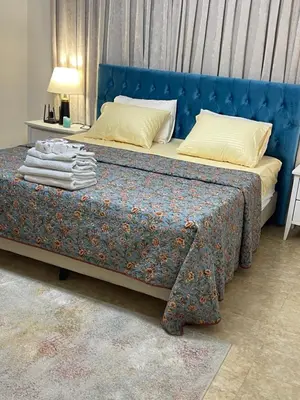 a bedroom with a bed with a blue head board at Beautiful & Cozy Newly remodeled 2 Bedroom in Amman