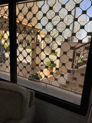 a window with a view of a patio with plants at Beautiful & Cozy Newly remodeled 2 Bedroom in Amman