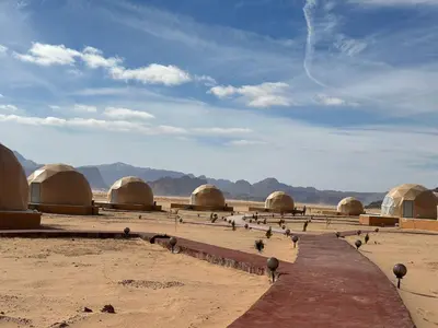 a group of domes in the desert with birds standing around at 7stars in Disah