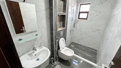 a white bathroom with a toilet and a sink at شقة بغرفه نوم واحدة عمو سامي in Amman