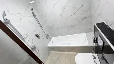 a white bathroom with a shower and a sink at شقق عمو سامي بغرفة نوم 1 in Amman