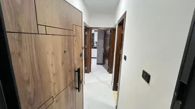 a hallway with wooden doors and a hallway with white walls at شقق عمو سامي بغرفتين نوم 2 in Amman