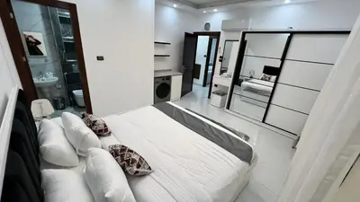 a bedroom with a white bed and a large mirror at شقق عمو سامي بغرفتين نوم 2 in Amman
