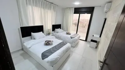 a bedroom with two beds and a large window at شقة رووف اطلاله رائعه عمو سامي 20 in Amman