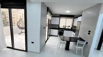 a kitchen and dining room with a table and chairs at شقة رووف اطلاله رائعه عمو سامي 20 in Amman