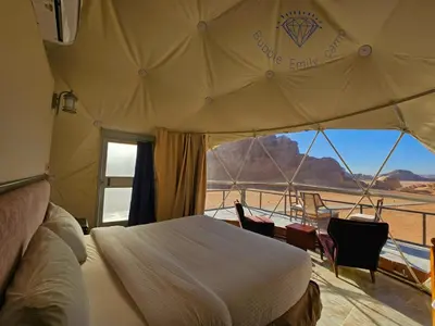 a bed in a tent with a view of the desert at Bubble Emily camp in Wadi Rum