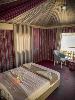 a bedroom with a bed and a chair in a tent at RUM NEPTUNE lUXURY CAMP in Wadi Rum