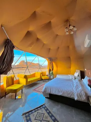 a bedroom with a large bed and yellow furniture at RUM NEPTUNE lUXURY CAMP in Wadi Rum