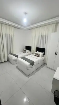 two beds in a large white room with curtains at شقة بثلاث غرف نوم 3 عمو سامي in Amman