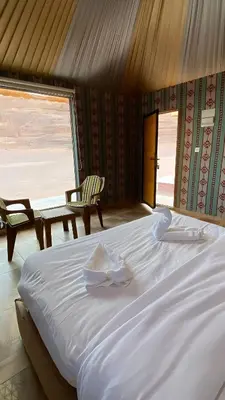 a large white bed in a room with a window at Romantic Moment Rum CAMP in Wadi Rum