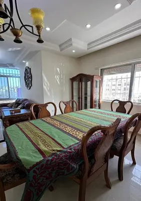 a bedroom with a bed with a green comforter at Tlaa al ali amman 3 rooms furnished apartment المحكمة الدستورية in Umm Uthainah