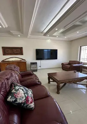 a living room with couches and a flat screen tv at Tlaa al ali amman 3 rooms furnished apartment المحكمة الدستورية in Umm Uthainah