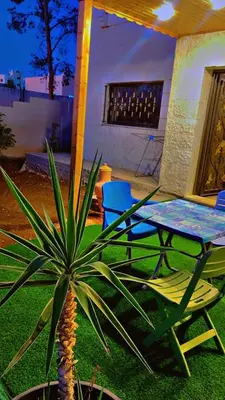 a patio with a table and a plant in the yard at Bait al salam in Um Qeis