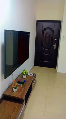 a bathroom with a sink and a mirror and a door at شقة فاخرة واسعة في شارع المدينة المنورة in Umm Uthainah