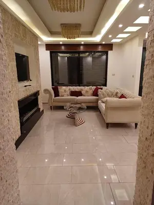 a large living room with couches and a fireplace at Apartment in Khalda in Amman
