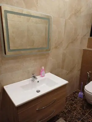 a bathroom with a sink and a mirror and a toilet at Apartment in Khalda in Amman