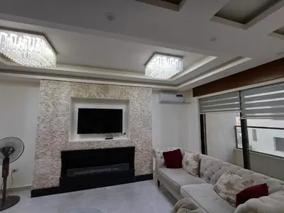 a living room with a couch and a fireplace at Apartment in Khalda in Amman