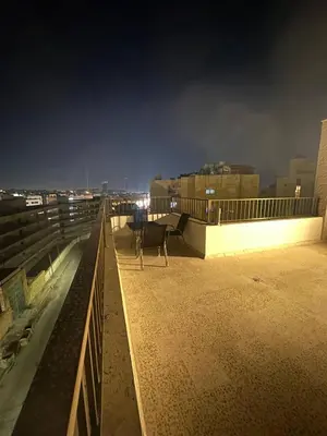 a chair sitting on top of a rooftop at night at Cozy and Tranquil Rooftop Near Al Services 23 in Amman