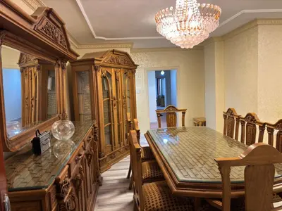 a dining room with a table and a chandelier at Zahrat AL-Mada'in apartment in Irbid