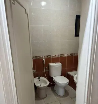 a small bathroom with a toilet and a sink at Zahrat AL-Mada'in apartment in Irbid