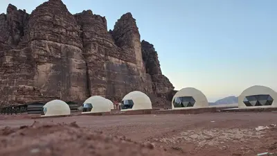 a group of domes in front of a mountain at Rum Honeymoon Camp in Wadi Rum