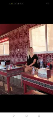 a woman sitting on a couch in front of a window at Rum Honeymoon Camp in Wadi Rum
