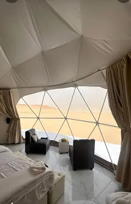 a room with a tent with a bed and two chairs at Rum Green Camp in Wadi Rum