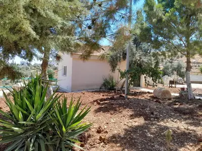 a small white building in a yard with trees at Jerash Roman Gate studio chalet ستوديو شاليه بوابة جرش الرومانيه الشماليه in Jerash