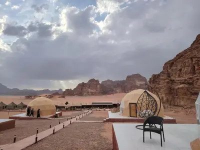 a view of a desert with tents and a chair at Desert Oasis Lodge in Wadi Rum in Disah