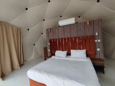 a bedroom with a bed in a tent at Desert Oasis Lodge in Wadi Rum in Disah