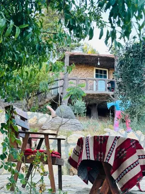 a picnic table and bench in front of a house at منتزه واكواخ كركوش in Ajloun