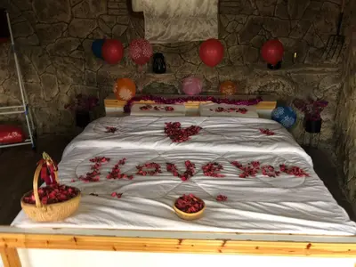 a bed with two baskets of red roses on it at منتزه واكواخ كركوش in Ajloun