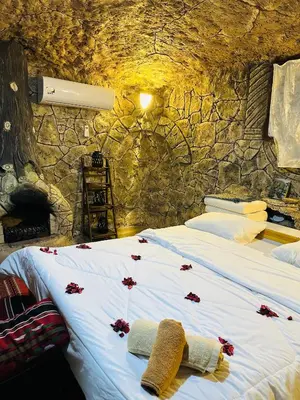 a bedroom with a bed with red flowers on it at منتزه واكواخ كركوش in Ajloun
