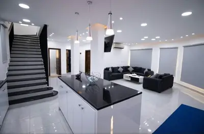 a kitchen and living room with a couch and a staircase at Gerasa Breeze resort in Rujm al Miḑmār