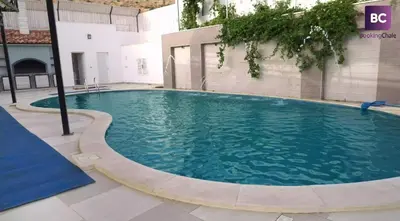a large swimming pool with a slide in a building at Gerasa Breeze resort in Rujm al Miḑmār