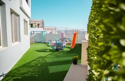 a balcony with a green yard with shopping carts at Gerasa Breeze resort in Rujm al Miḑmār
