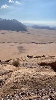 a view of a desert with mountains in the distance at desert Hawk in Wadi Rum