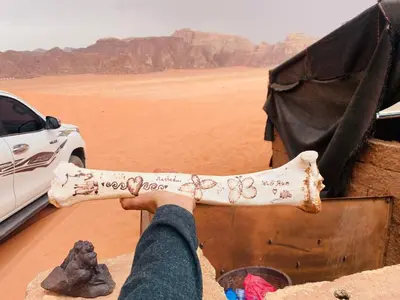 a person holding a bone in the desert at desert Hawk in Wadi Rum